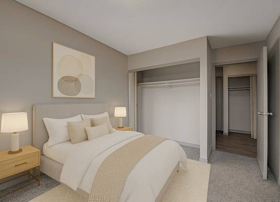 A cozy bedroom here at Cedar Gardens with soft neutral tones and a comfortable bed setup, featuring matching nightstands with warm lamps, simple wall art above the headboard, and a spacious closet area for an airy, relaxing feel.