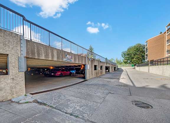 A convenient covered parking garage here at Gateway Square with clearly marked spaces, easy drive-in access, and open surroundings under a bright blue sky.