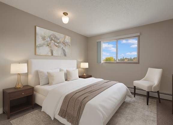 A bright bedroom here at Gateway Square featuring a cozy bed with crisp white bedding and soft neutral pillows, paired with matching nightstands and warm table lamps, plus elegant wall art and a plush accent chair for a calm, relaxing retreat.