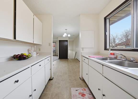 A kitchen with white cabinets and a sink.