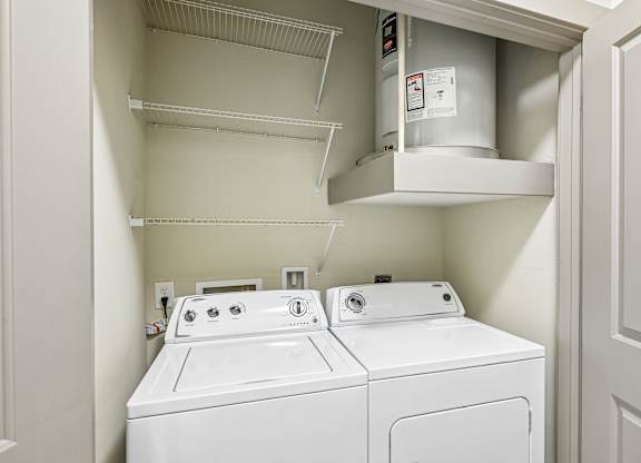 A white washing machine and dryer in a small laundry room.
