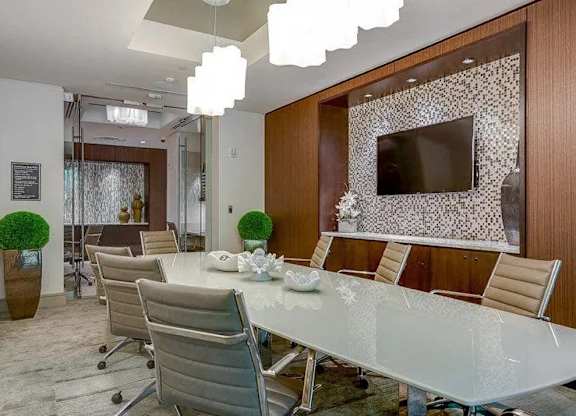 A conference room with a long table and chairs.
