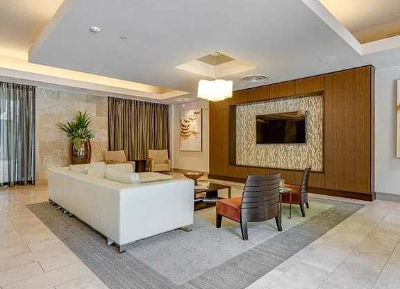 A living room with a white sofa and a wooden entertainment center.