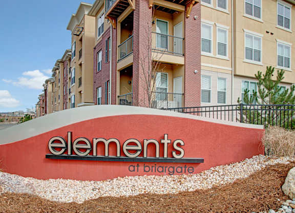 A red sign with the word elements on it in front of a building.