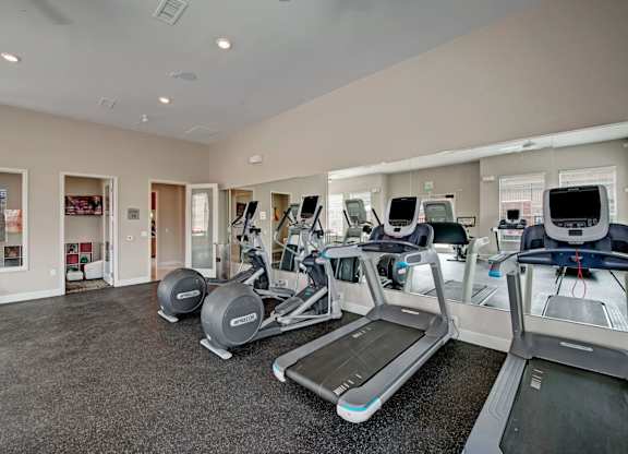 A gym with treadmills and elliptical machines.