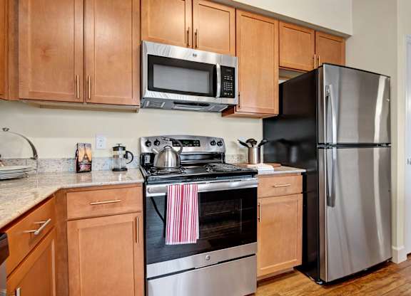 A kitchen with a stove, oven, refrigerator, and microwave.