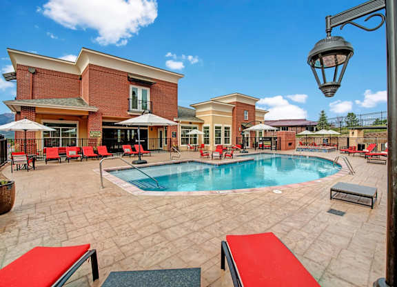 A pool area with a red bench and a lamp post.