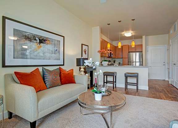 A living room with a couch, coffee table, and a painting on the wall.