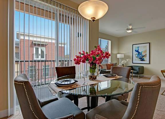 A dining room with a glass table and chairs.