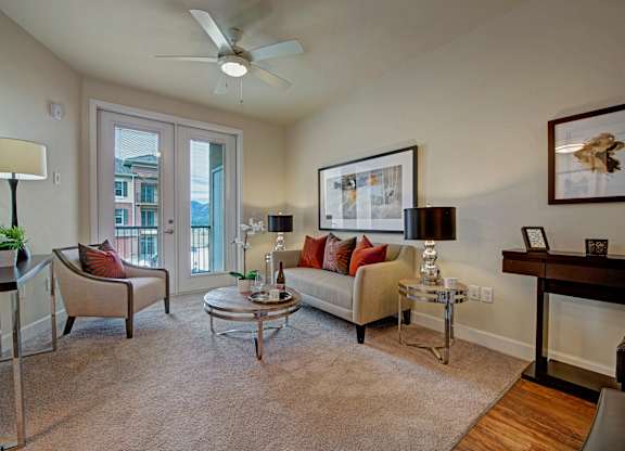 A living room with a fan, a couch, and a table.