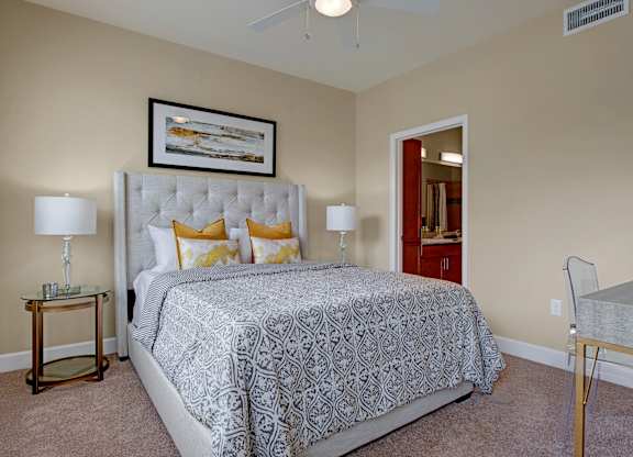 A bedroom with a large bed and a ceiling fan.