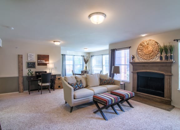a living room with a couch and a chair in front of a fireplace