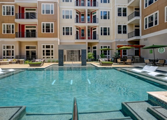 a large swimming pool in front of an apartment building