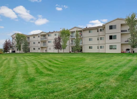 a large green lawn in front of an apartment building