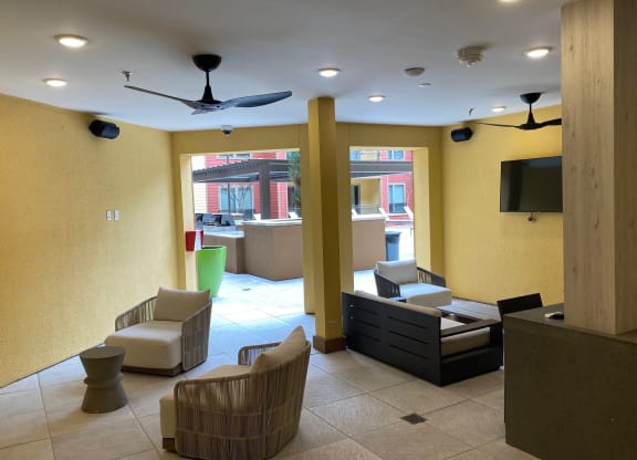 a lobby with chairs and a couch and a tv