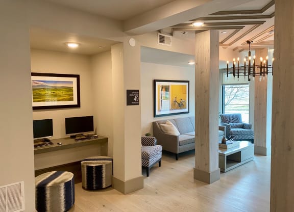 a living room with couches and a desk and a tv