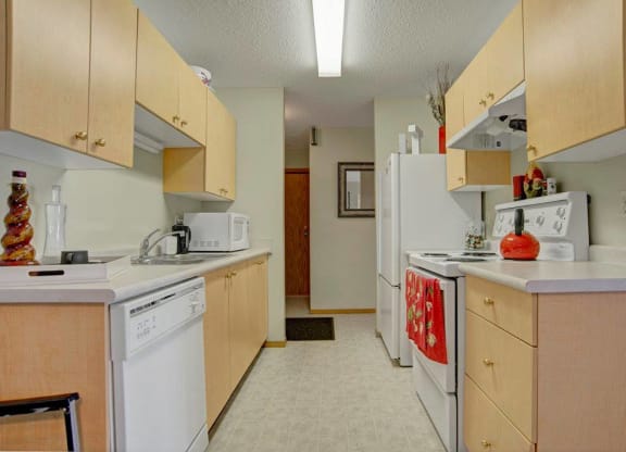 a kitchen with white appliances and wooden cabinets
