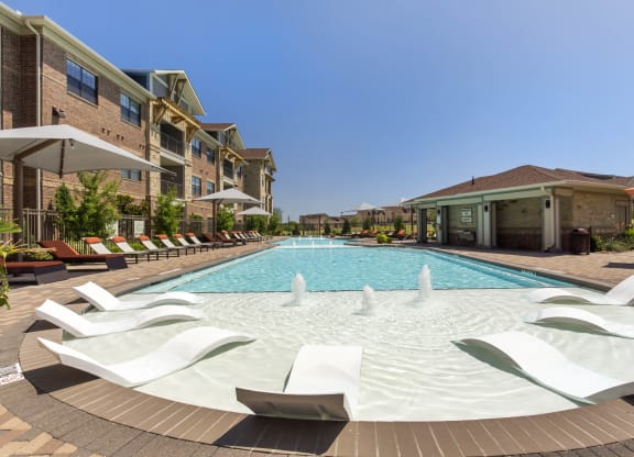 the preserve at ballantyne commons pool with lounge chairs and building with water feature