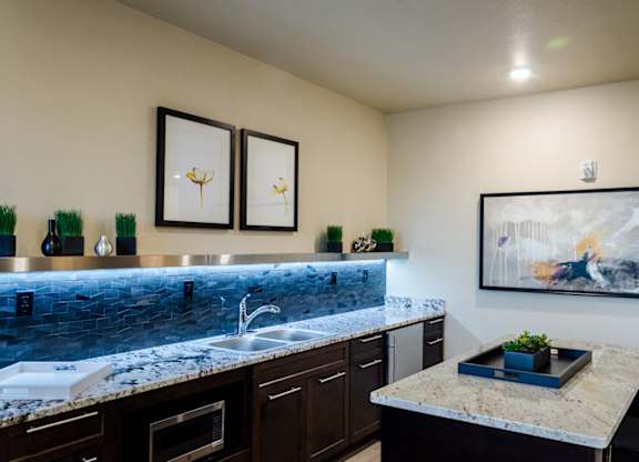 A kitchen with a marble countertop and a painting on the wall.