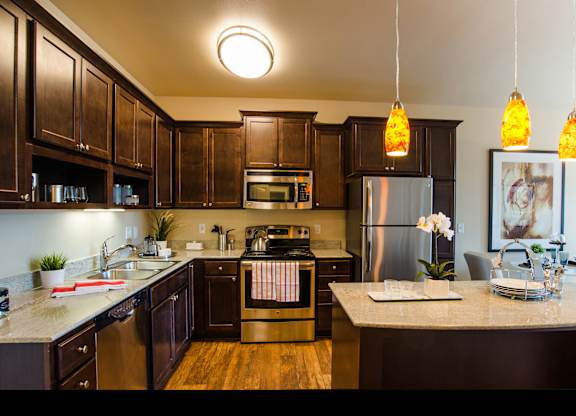 A kitchen with dark wood cabinets and stainless steel appliances.