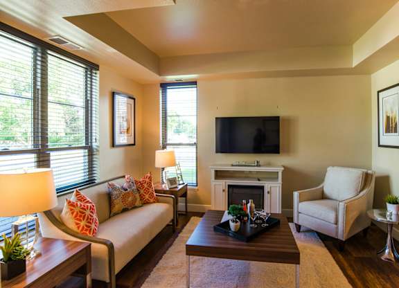 A living room with a couch, chair, and fireplace.