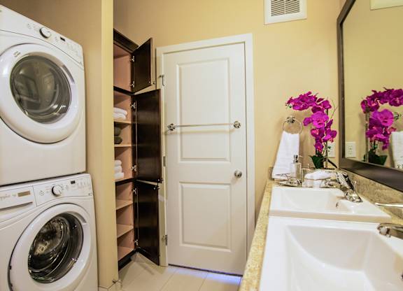 A white washing machine is in a small laundry room.