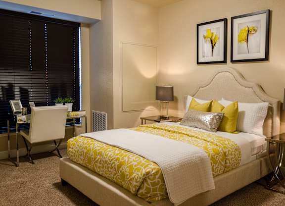 A bedroom with a large bed and a desk with a chair.