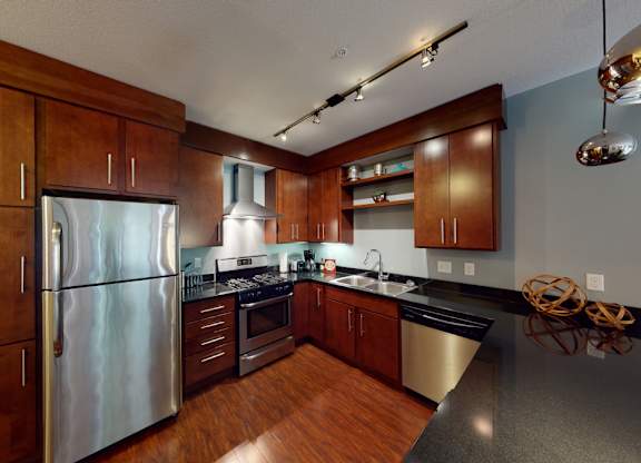 A modern kitchen with wooden cabinets and stainless steel appliances.