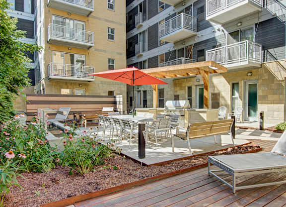 A patio with a table and chairs and an umbrella.