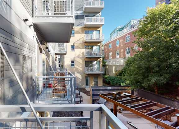 A modern building with a balcony and a tree.