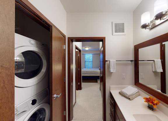A bathroom with a washer and dryer built into the cabinet.