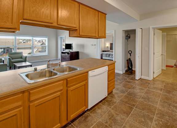 A kitchen with wooden cabinets and a tiled floor.