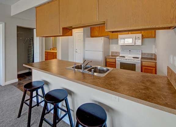 A kitchen with a white refrigerator, a white oven, and a white microwave.