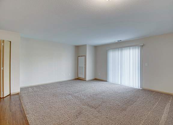 A carpeted room with a sliding glass door.