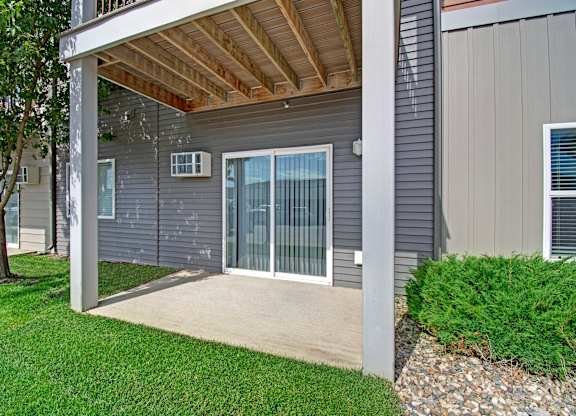 A grey house with a covered patio.