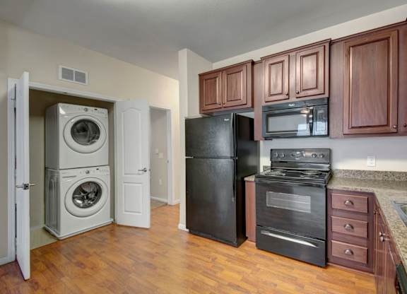 A kitchen with black appliances and wooden cabinets.