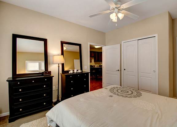 A bedroom with a bed, dresser, and mirror.