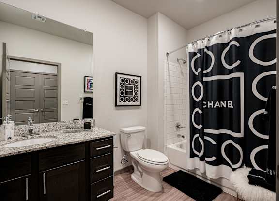 A bathroom with a sink, toilet, and a shower curtain.