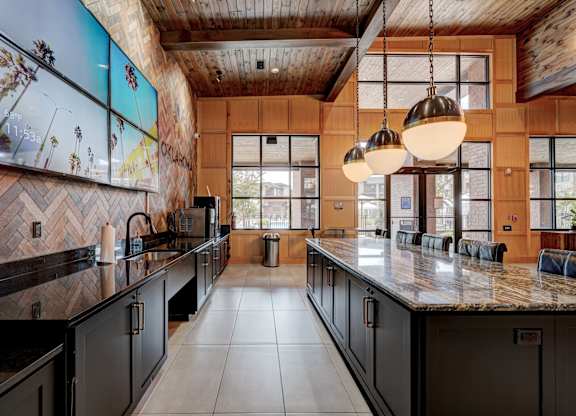 A modern kitchen with a wooden ceiling and black cabinets.