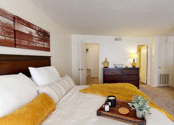 A bedroom with a bed, dresser, and nightstand.