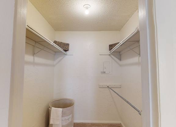 A small, white closet with a white door and a white wall.