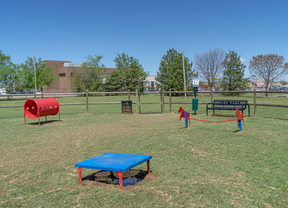 A playground with a blue tarp and a red barrel.