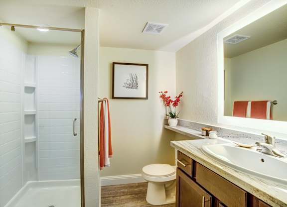 A bathroom with a toilet, sink, and shower.