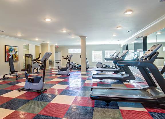 A gym with treadmills and elliptical machines.