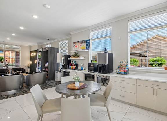 A modern kitchen with a dining table and chairs.