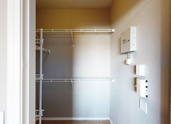 A white doorway opens to a room with a white wall and a white shelf.