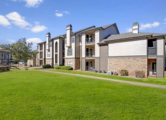 A row of modern houses with a green lawn in front.