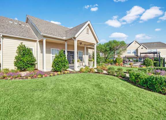 A house with a well-manicured lawn in front.