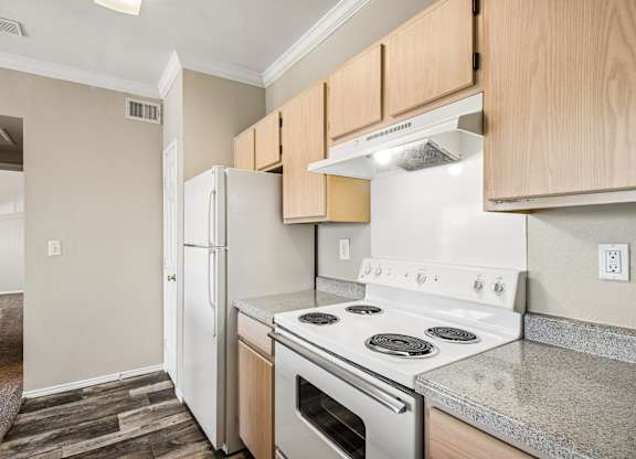 A kitchen with a white stove top oven and white refrigerator.