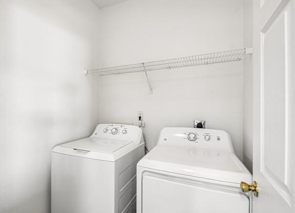 A white washing machine and sink in a small bathroom.